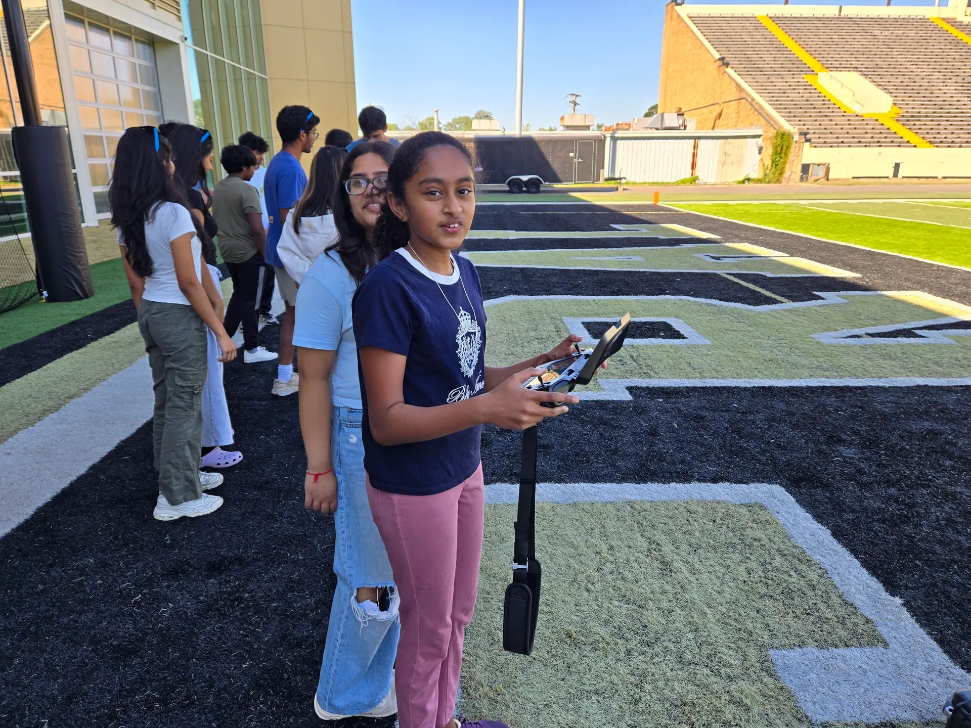Students take the controls at a school athletic field during a Grace3 education session.