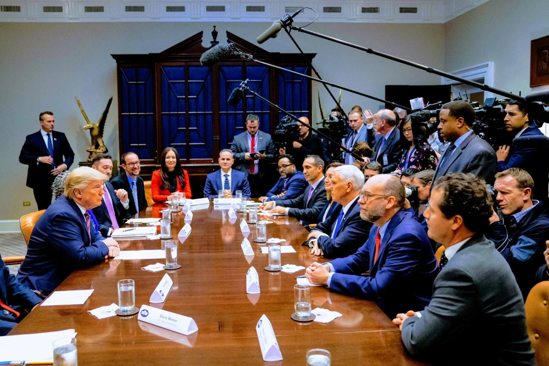 Federal leaders and press gathered around a conference table